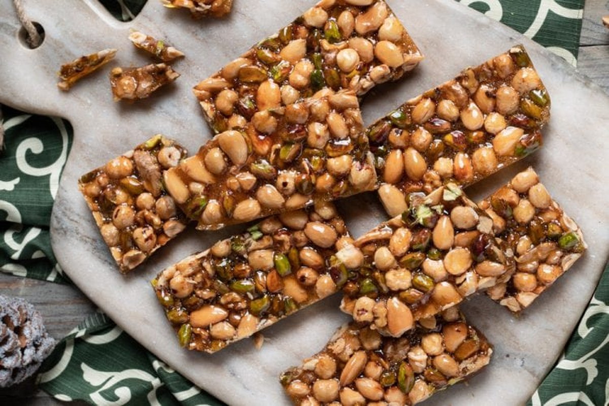 Barattoli di vetro con frutta secca assortita su un tavolo di legno.
