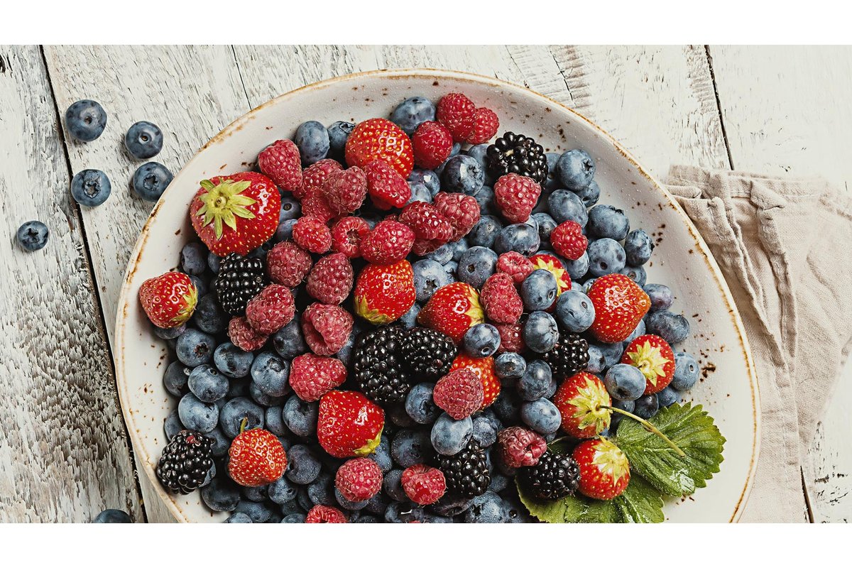 Frutti di bosco surgelati in un sacchetto trasparente su un tavolo di legno.