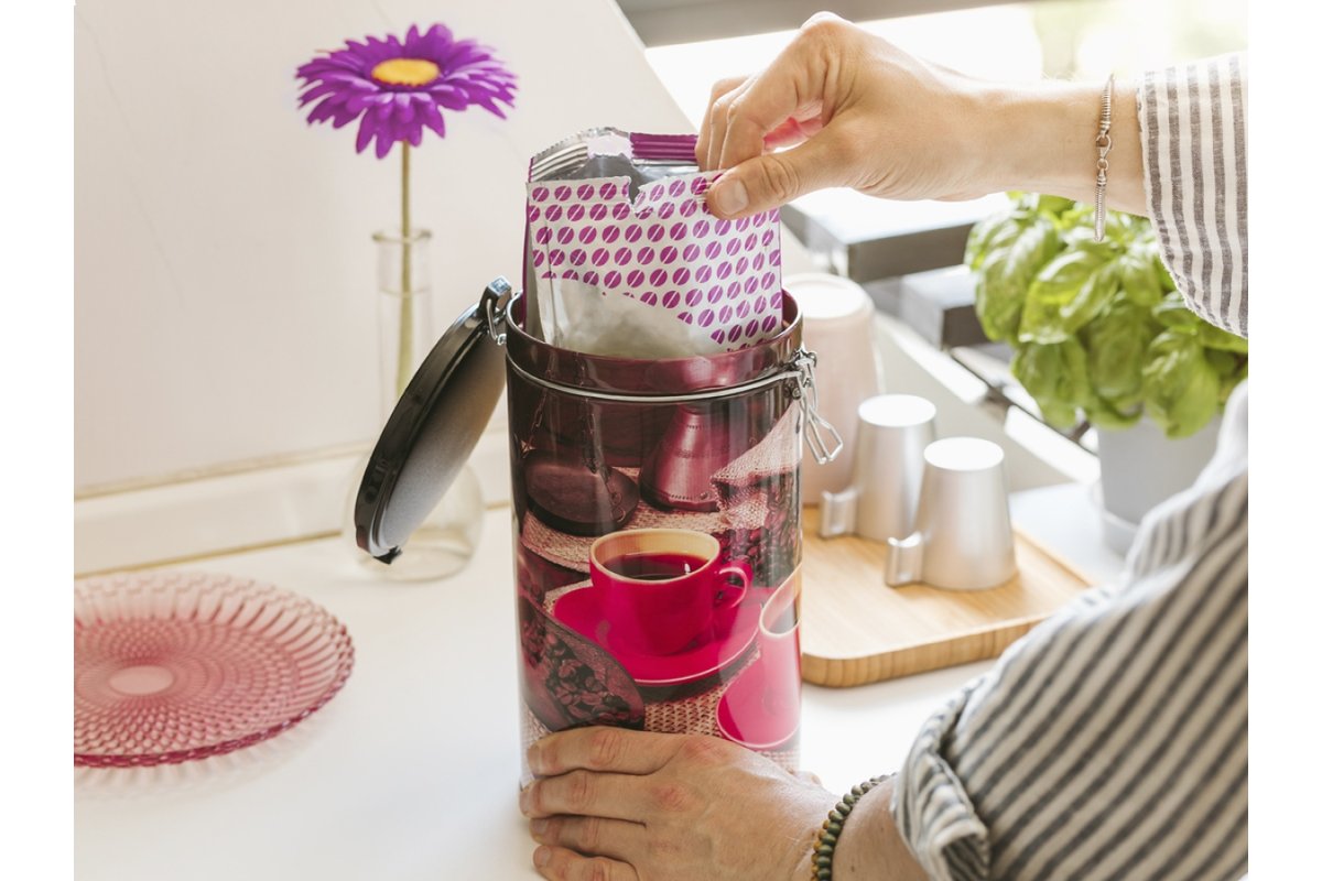 Chicchi di caffè freschi in un barattolo di vetro aperto.