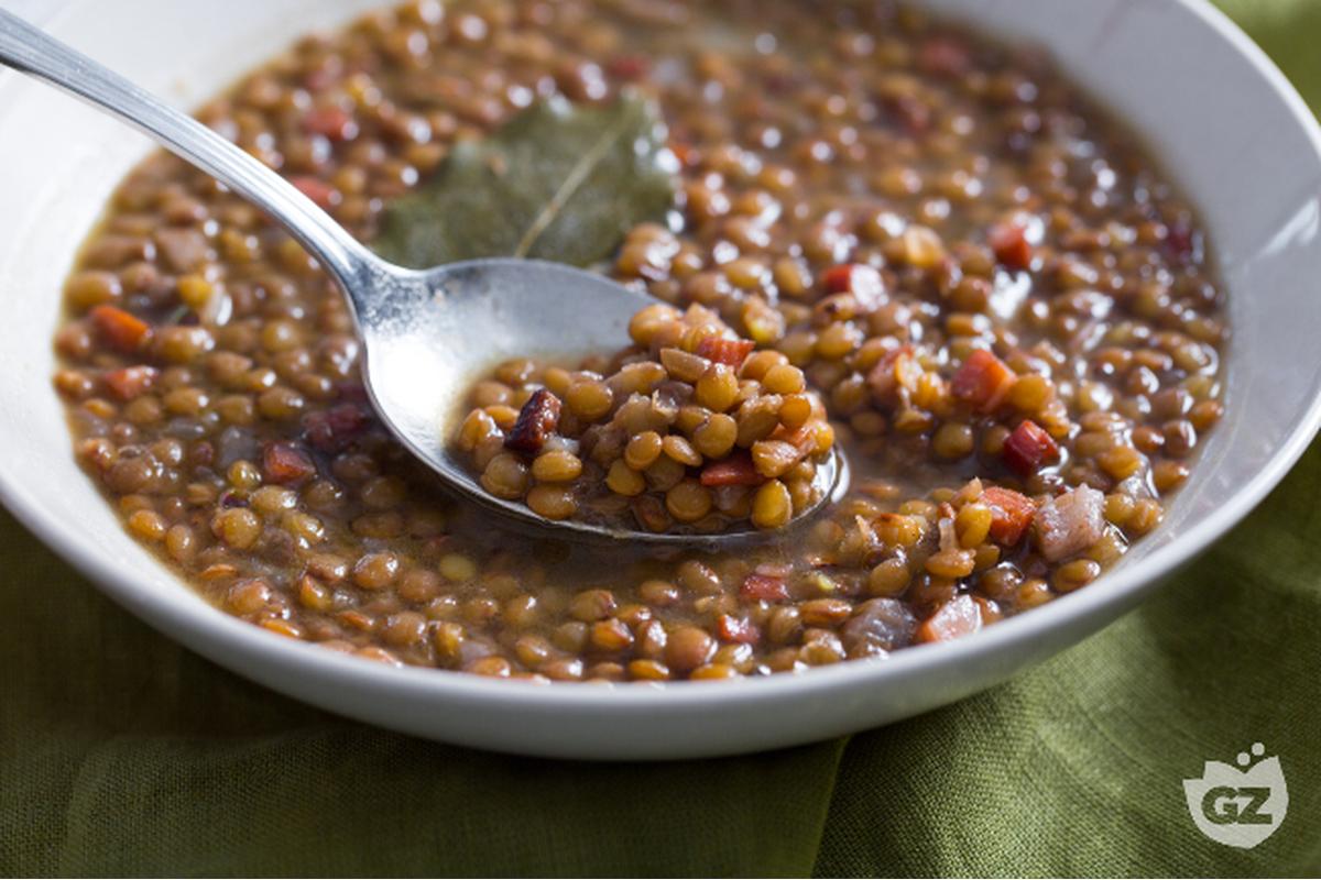 "Lenticchie su tavola di legno: superfood economico che contrasta l'invecchiamento meglio della carne."