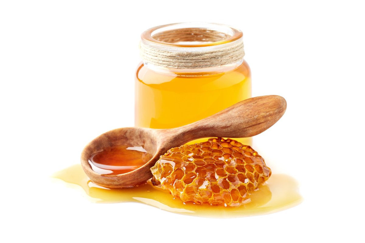 Barattolo di miele cristallizzato su un tavolo di legno.