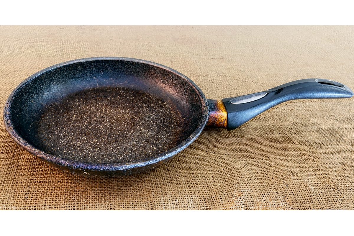 Padella annerita prima della pulizia con ingredienti naturali.