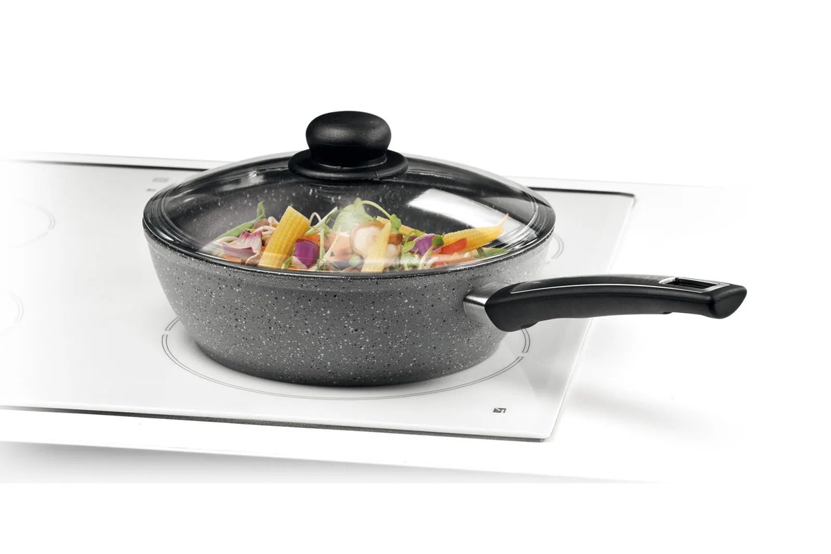 Coperchi di pentole brillanti su un piano di lavoro della cucina