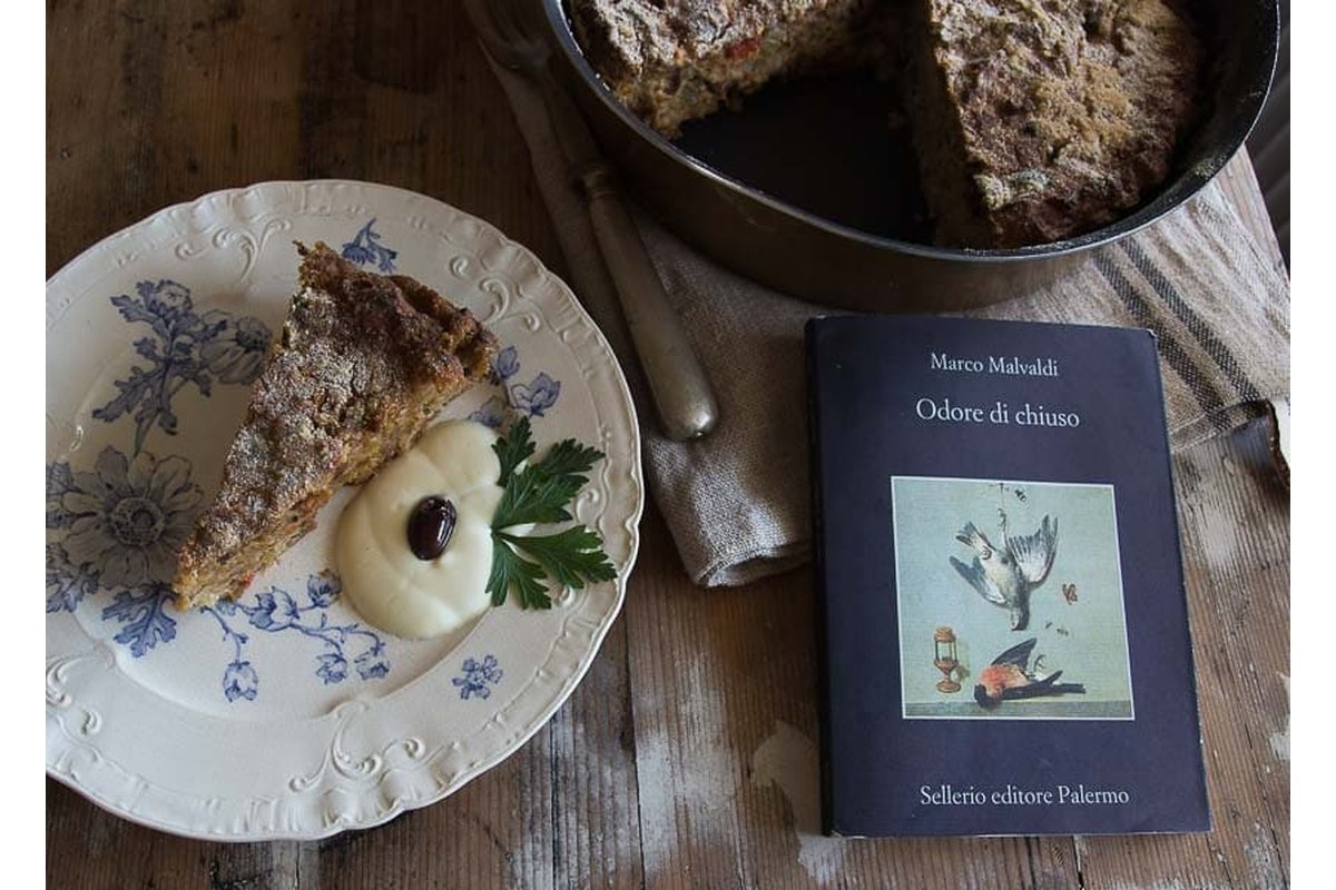Vecchi libri impilati su uno scaffale polveroso in una cantina.