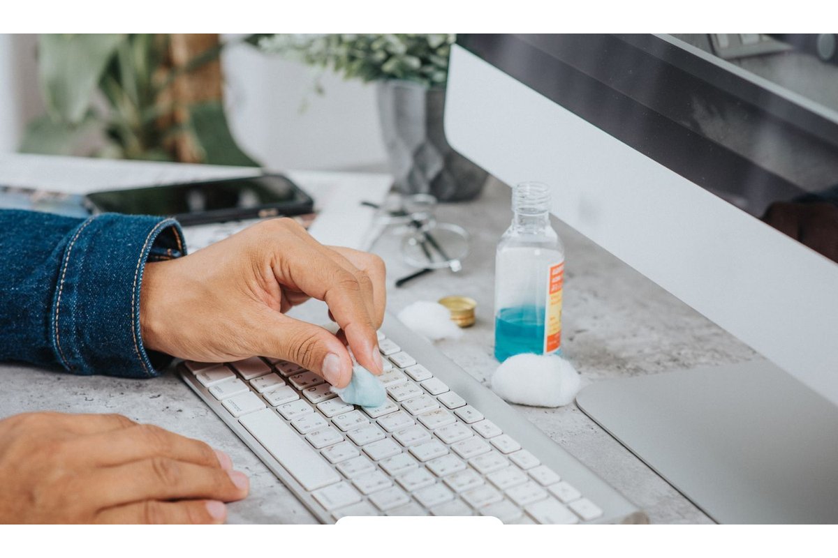 Persona che pulisce uno schermo con un panno e spray detergente